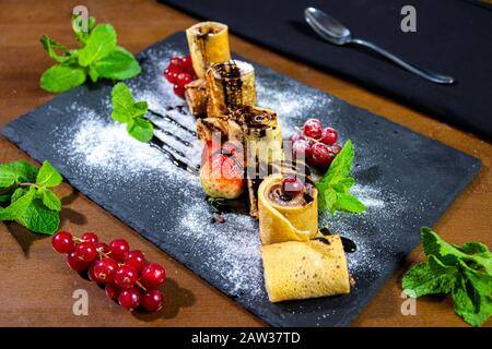 Schokoladenkrepes mit Früchten und Minze Stockfoto