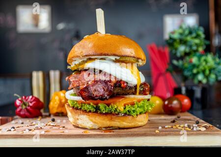 Saftiger Burger auf Holzplatte Stockfoto