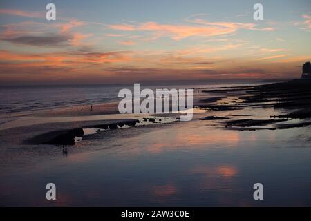 Menschen am Strand bei Ebbe, St leonards on Sea, East Sussex, Großbritannien Stockfoto