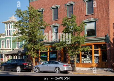 26. Juli 2019 - Town of Clayton, NY, USA: Gebäude und Autos, die im Sommer am Riverside Dr geparkt wurden Stockfoto