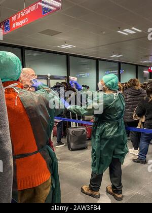 Februar 2020. Touristen, die am Flughafen Bergamo in Italien ankommen, werden wegen des Ausbruchs des Coronavirus von Mitarbeitern mit elektronischen Thermometern gescannt Stockfoto