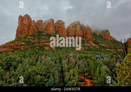 Die roten Felsen von Sedona Arizona, die an einem trüben und regnerischen Morgen mit Nebel zu dampfen scheinen. Stockfoto