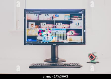 Computerdesktop mit Shutterstock Fotograf Portfolio auf dem Bildschirm. Tastatur und Kaffeebecher auf weißem Tisch. Retro-Look. Stockfoto