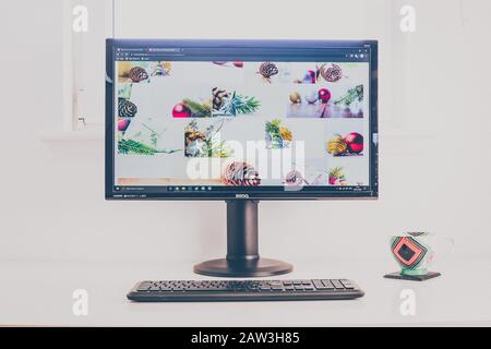 Computerdesktop mit Shutterstock Fotograf Portfolio auf dem Bildschirm. Tastatur und Kaffeebecher auf weißem Tisch. Retro-Look. Stockfoto