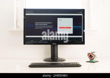 Computerdesktop mit Shutterstock Website auf dem Bildschirm. Tastatur und Kaffeebecher auf weißem Tisch. Retro-Look. Stockfoto