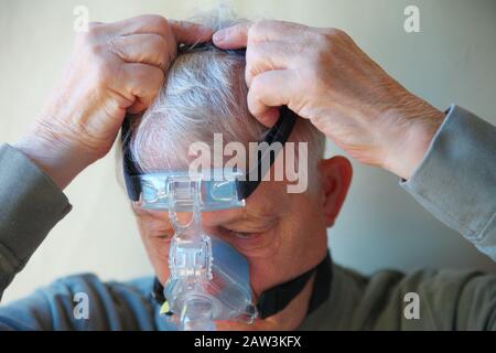 Oberpatient mit Kopfbedeckung des Schlafapnoe-Behandlungsgeräts Stockfoto