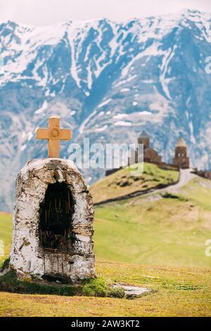 Stepantsminda, Gergeti, Georgia. Überqueren Sie Die Steine Auf Den Bergen Hintergrund In Der Nähe Der Gergeti Trinity Tsminda Sameba Kirche. Stockfoto