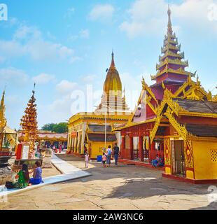 Bagan, MYANMAR - 25. FEBRUAR 2018: Das Gelände der Shwezigon-Pagode mit malerischen Bilderhäusern und Schreinen, dekoriert mit geschnitzten Holz- und goldenen Deta Stockfoto