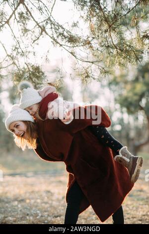 Mutter und Tochter spielen und haben Spaß beim gehen im Kiefernwald. Stockfoto