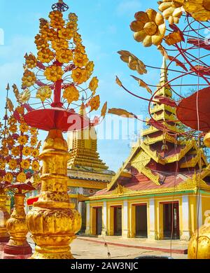 Erkunden Sie das Gelände der Shwezigon-Pagode mit malerischen Dekorationen goldener Blumen und verzierten Schreinen, die mit Pyathondächern oder Sikhara-Türmen, Bag, bestaunen Stockfoto