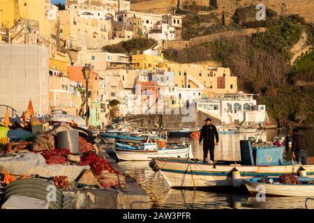 Procida, ITALIEN - 3. JANUAR 2020 - Blick auf die Corricella-Bucht im Sonnenuntergang, einem romantischen Fischerdorf in Procida, Italien Stockfoto