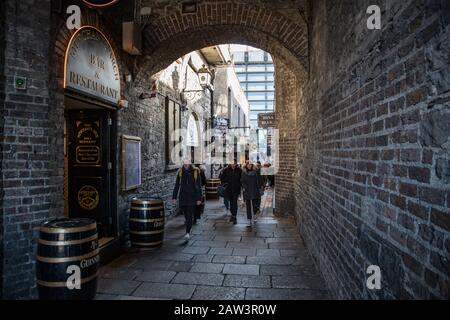 Dublin, Irland - 29. Januar 2020: Menschen, die durch Merchants Arch in Temple Bar, Dublin, Stockfoto