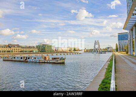 Berlin, Deutschland - 29. Oktober 2013: An der Spree, Bezirk Treptow, mit altem Schiffs- und Bildhauermolekül Mann im Hintergrund. Stockfoto