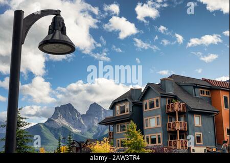 Holzgebäude mit felsigen Bergen und Straßenbeleuchtung in der Innenstadt von Canmore, Kanada Stockfoto