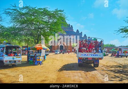 Bagan, MYANMAR - 25. FEBRUAR 2018: Die Lastwagen mit Bhikkhu-Monks, Pilgern und Touristen kommen am 25. Februar auf den Parkplatz des Dhammayangyi-Tempels Stockfoto