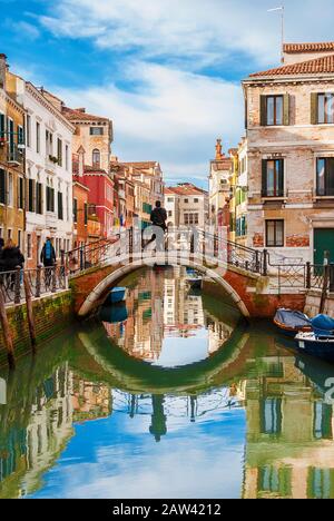 Blick auf den Kanal Rio Marin mit seinen farbenfrohen Häusern und Touristen im historischen Zentrum von Venedig Stockfoto