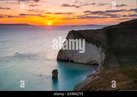 Lulworth, Dorset, Großbritannien. Februar 2020. Wetter in Großbritannien. Ein goldener Sonnenuntergang bei Bats Head in der Nähe von Lulworth in Dorset mit Blick nach Westen in Richtung Weymouth und auf die Insel Portland, vom South West Coast Path auf Swyre Head aus gesehen. Bildnachweis: Graham Hunt/Alamy Live News Stockfoto