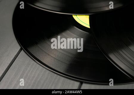 Drei traditionelle schwarze Platten aus glänzendem Vinyl ohne Kratzer auf einem grauen Holztisch Stockfoto