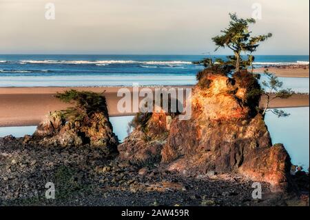 Gesteine an der Einmündung des Siletz River bei Ebbe in Lincoln City an der Küste von Oregon Stockfoto