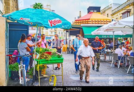 Jerez, SPANIEN - 20. SEPTEMBER 2019: Die Verkaufsstände für Obst und Gemüse und der Imbisspavillon für Churros in der belebten Donna Blanca Straße, am 20. September in Jerez Stockfoto