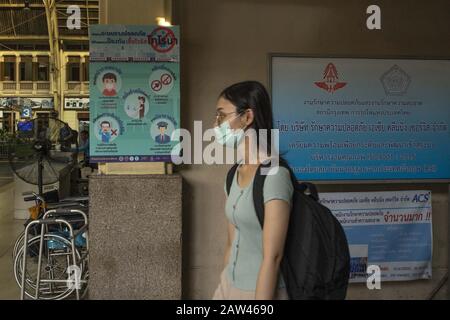 Bangkok, Bangkok, Thailand. Februar 2020. Eine Frau, die eine schützende Gesichtsmaske trägt, geht an einem Plakat in Bangkoks historischem Bahnhof Hualumphong vorbei und zeigt Ratschläge, wie man die Ausbreitung von Coronavirus Credit verhindern kann: Adryel Talamantes/ZUMA Wire/Alamy Live News Stockfoto