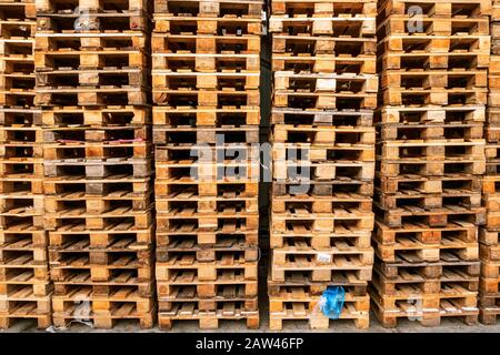 Viele Stapel gebrauchte Holzpaletten vom Euro-Typ im Lager sind bereit für das Recycling. Industrieller Hintergrund. Nahaufnahme. Im Freien. Stockfoto