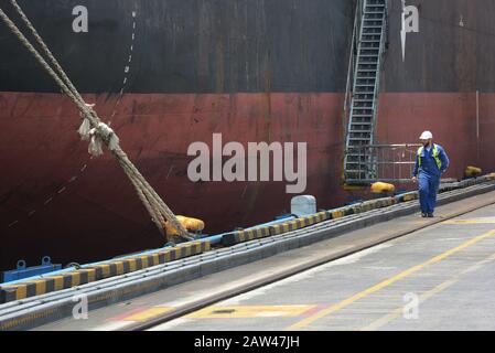 Die Arbeiter führen am 6. April 2019 Containerladen und Entladeaktivitäten vom Schiff MV Holsatia (Großbritannien) bis 699 980 (Liegeplatz 04) im Internationalen Hafen von PT Surabaya Petikemas Terminal (TPS), Surabaya, East Java, Indonesien durch. PT Terminal Petikemas Surabaya beginnt, die Lade- und Entladedienste auf einem Schiff zu erhöhen, das zuvor nur 1.700 bis 2.000 Kisten oder 2.700 TEUs gemittelt hatte. Derzeit ist TPS in der Lage, Schiffe mit der größten Ladung von über 3.100 Containern oder rund 4.600 TEUs für den Handel in ganz Asien zu bedienen. Stockfoto