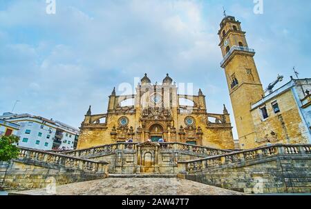 Jerez, SPANIEN - 20. SEPTEMBER 2019: Das mittelalterliche Architekturensemble der Heilig-Erlöser-Kathedrale mit komplexer Treppe, szenischer Fassade mit fliegender aber Stockfoto