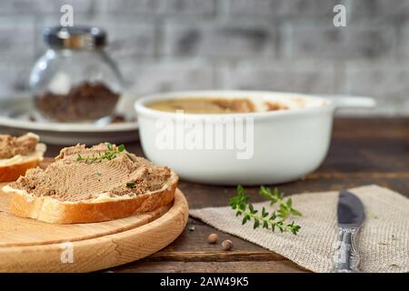 Toast mit Hühnerleberpate auf Holztisch. Rezeptkonzept Stockfoto