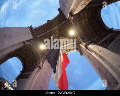 Paris, Frankreich - 19. März 2019. Arc de Triomphe Paris und Champs Elyssees mit einer großen französischen Flagge, die unter dem Bogen in Europa den Siegestag in Paris erreicht Stockfoto