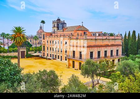 Das ockerfarbene Gebäude des Palastes von Villavicencio, in Alcazar gelegen und umgeben von viel Grün historischer Gärten, Jerez, Spanien Stockfoto