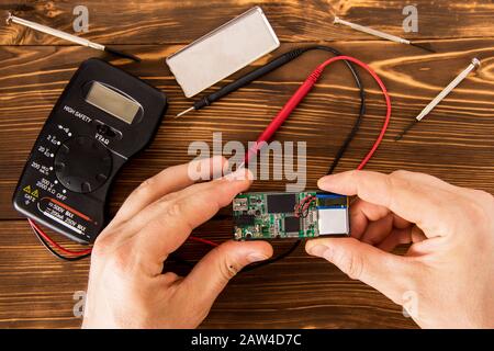 Radioelektronischer Prüfsatz für Lötdraht und Schrumpflötschlauch mit Lötmittel neben Schraubendreher und Multimeter auf Holzhintergrund, Radio e Stockfoto