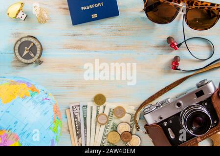 Tour Planen konzeptionelles Bild auf blauem Holzhintergrund alte Fotokamera, Dolare, Mammakarte, Pass- und Kartengläser Kopfhörer mit Copyspace Stockfoto