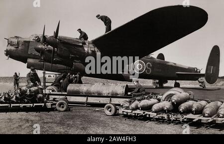 RAF Ground Crew, die einen schweren Bomber vom Typ Avro Lancaster, British Second World war, von 467 (RAAF) Squadron I mit 4.000 Pfund und 500 Pfund schweren Bomben mittlerer Kapazität beladen. Der lange, ungehinderte Bombenschacht des Flugzeugs bedeutete, dass die Lancaster die größten von der RAF verwendeten Bomben aufnehmen konnte, darunter die Blockbuster 4.000 lb (1.800 kg), 8.000 lb (3.600 kg) und 12.000 lb (5.400 kg), Lasten, die oft mit kleineren Bomben oder Brandstiften ergänzt wurden. Die "LANC", wie sie in der Kolloquie bekannt war, wurde zu einem der am stärksten genutzten Nachtbomber des Zweiten Weltkriegs. Stockfoto