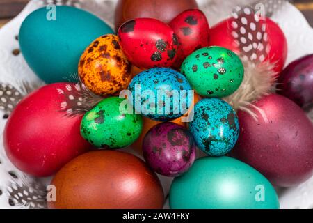 Frohe Ostern. Bemalte Eier verschiedener Farben auf einem Holztisch Stockfoto