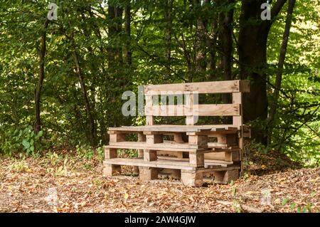 Holzbank aus alten gebrauchten Transportpaletten in Waldhöhe Stockfoto