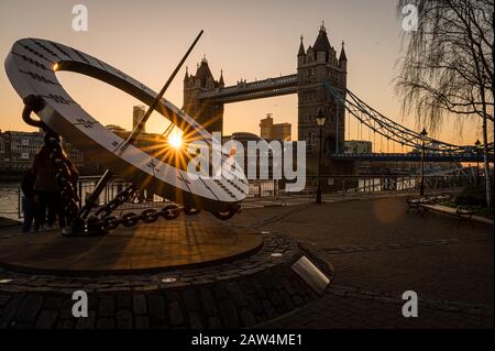 Das Zeitmesser Sundial und Tower Bridge bei Sonnenuntergang in London, Großbritannien Stockfoto