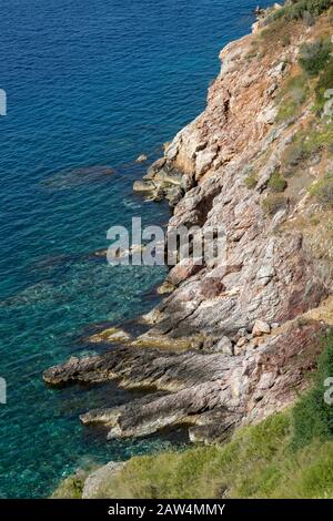 Felsige Küste entlang der griechischen Insel Hydra. Eine der Saronischen Inseln in der ägetischen See. Stockfoto