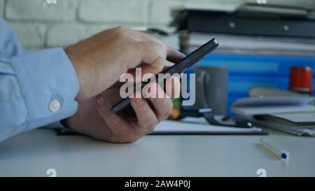 Businessman in Office Room Text Senden von Geschäftsinformationen Über Handy drahtlose Kommunikation Stockfoto