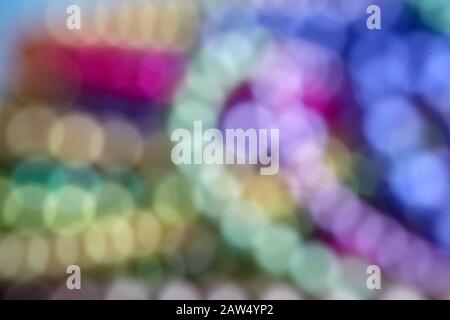 Entschärfte leuchtende Bokeh-Lichter. Mardi Gras färbt Hintergrund Stockfoto