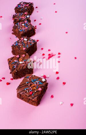 Schokoladenbrownie Dessert mit Mandeln innen, festliches Pulver, auf pinkfarbenem Hintergrund. Ansicht von oben Stockfoto