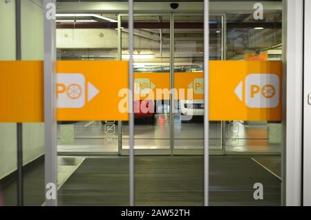 Garageneingang, geöffnete Glastür in einem Einkaufszentrum mit Parkmarke Stockfoto