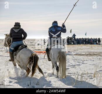 Zhezkazgan, Kasachstan. Februar 2020. Zwei kasachische Pferdebeobachtern als Rettungskräfte bergen das Raumschiff Sojus MS-13 nach einem Touchdown mit den Besatzungsmitgliedern der Expedition 61 NASA-Astronautin Christina Koch, dem ESA-Astronauten Luca Parmitano und dem Kosmonauten Roskosmos Alexander Skvortsov 6. Februar 2020 in einem abgelegenen Gebiet in der Nähe der Stadt Zhezkazgan, Kasachstan. Koch kehrte zur Erde zurück, nachdem er 328 Tage im All, dem längsten Raumflug einer Frau in der Geschichte, als Mitglied der Expeditions 59-60-61 auf der Internationalen Raumstation einloggt hatte. Kredit: Bill Ingalls/NASA/Alamy Live News Stockfoto