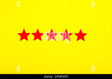 5 Sterne erhöhen die Bewertung, Customer Experience Concept. 5 rote Sterne ausgezeichnete Bewertung auf gelbem Hintergrund. Stockfoto
