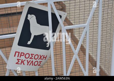 (Englisch: Vorsicht vor Hund) Schild Griechisch an einem Metalltor in Larnaka hängen Stockfoto