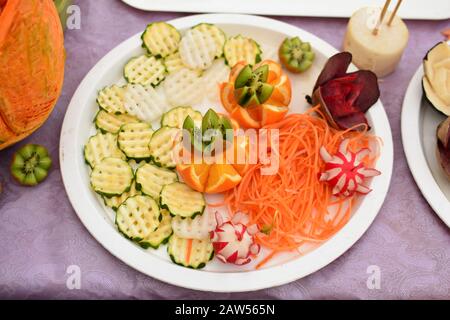 Geschnitztes Obst und Gemüse auf der weißen Kunststoffplatte Stockfoto