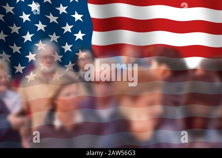 Große USA-Flagge mit Gruppen verschwommener Menschen im Vordergrund. Patriotisches, Wahl- oder Touristenkonzept. Stockfoto