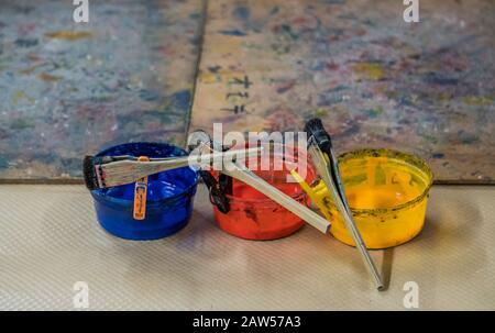 Drei verschiedene Farben stehen auf dem Tisch. Fantastische Kunstschule in Japan. Japanische Werkstatt arbeitet an Kunstwerken in einer Spezialschule. Berühmte Maler. Stockfoto
