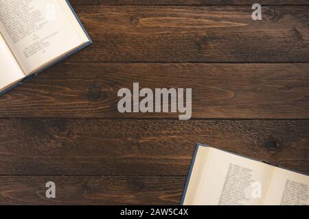 Offene Bücher isoliert auf Holzhintergrund. Flaches Layout, Draufsicht, Kopierbereich. Stockfoto
