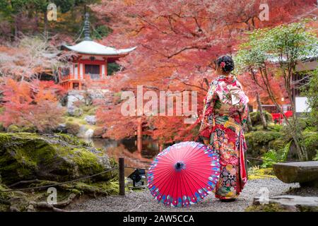 Junge japanische Mädchen Reisende im traditionellen Kiminokleid im Digoji-Tempel mit roter Pagode und rotem Ahorn-Blatt in der Herbstsaison in Kyoto, Japan Stockfoto